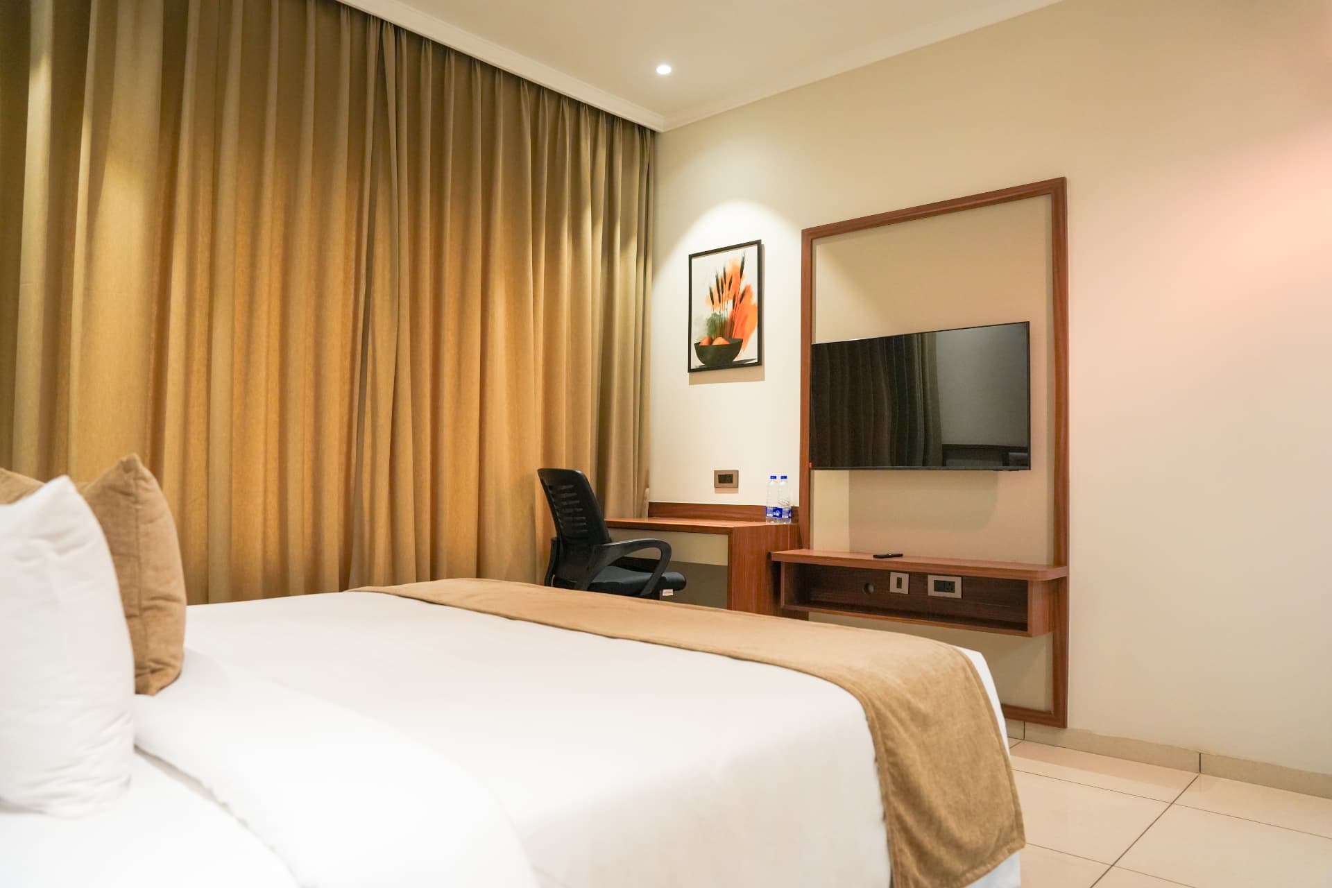 The Premium Room desk and television viewed across the bed