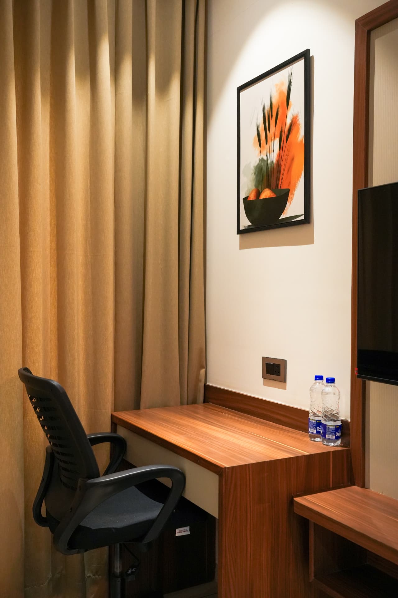 The Premium Room desk and chair beside the curtained window