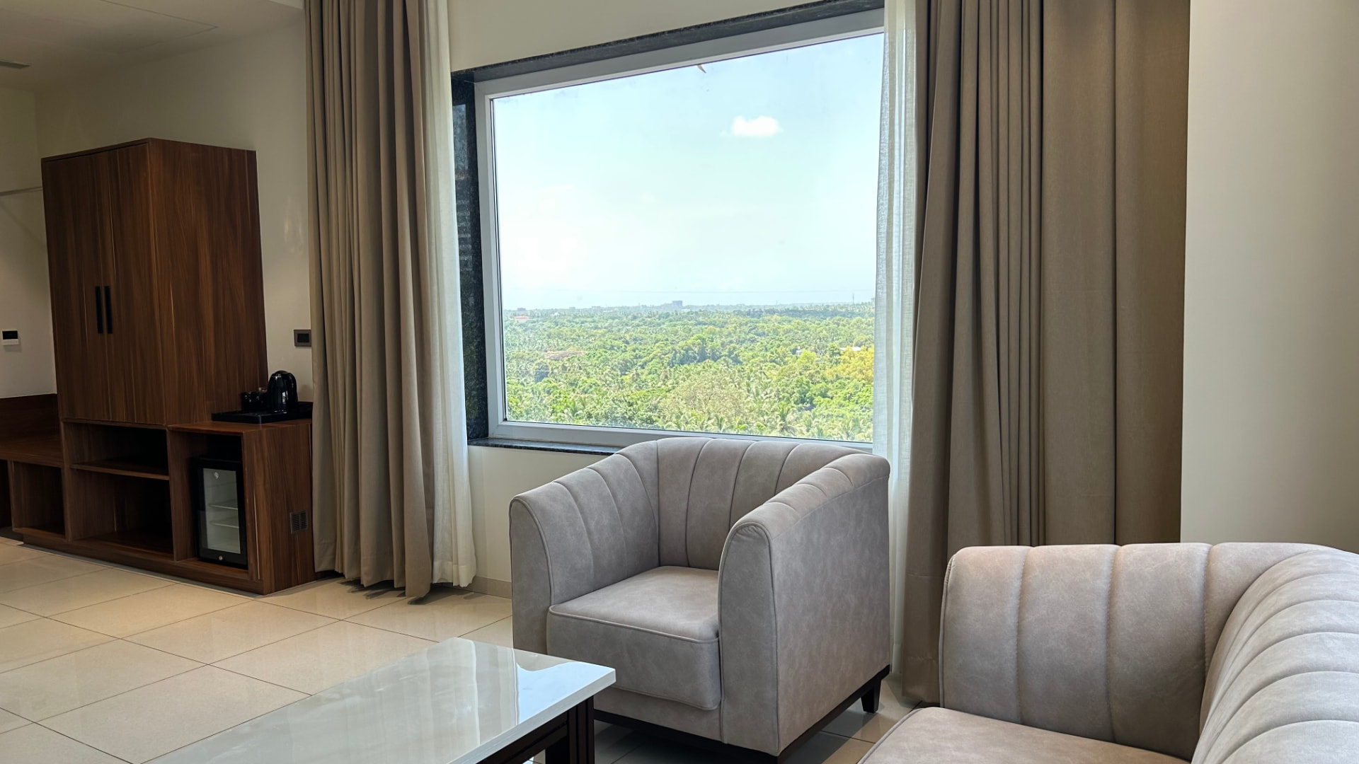 The Suite lounge with wood cabinetry and the window onto greenery